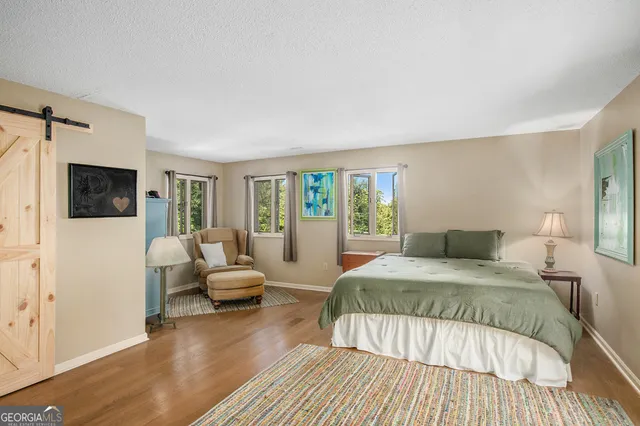 a bedroom with a bed wooden floor and window