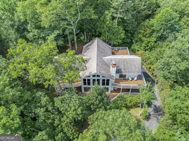 an aerial view of a house with a yard and large trees