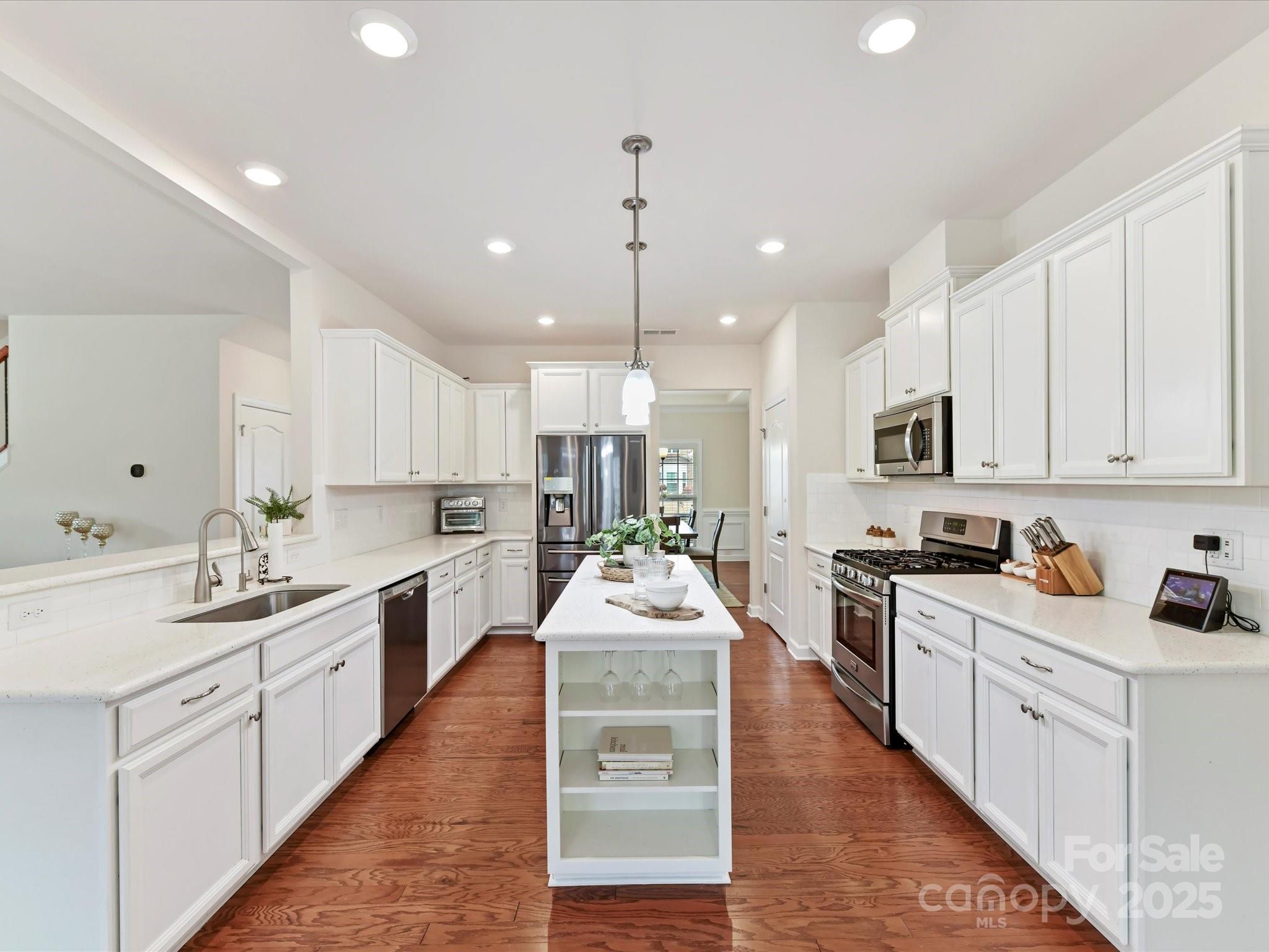 9895 Travertine Trail Davidson, NC 28036 - Photo 13 of 48 a large kitchen with kitchen island lots of counter space a sink stainless steel appliances and cabinets