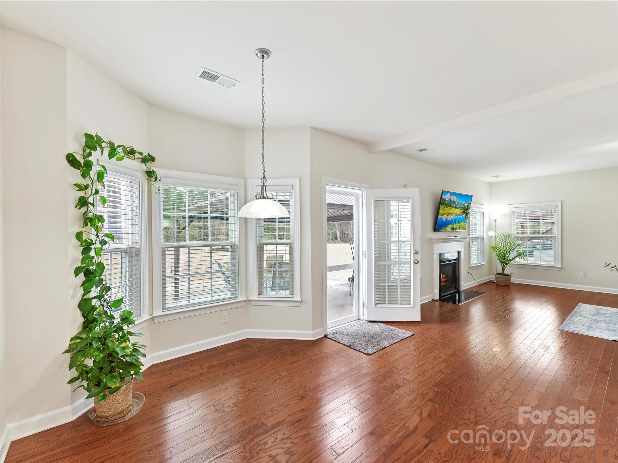 9895 Travertine Trail Davidson, NC 28036 - Photo 17 of 48 a view of empty room with wooden floor and potted plant