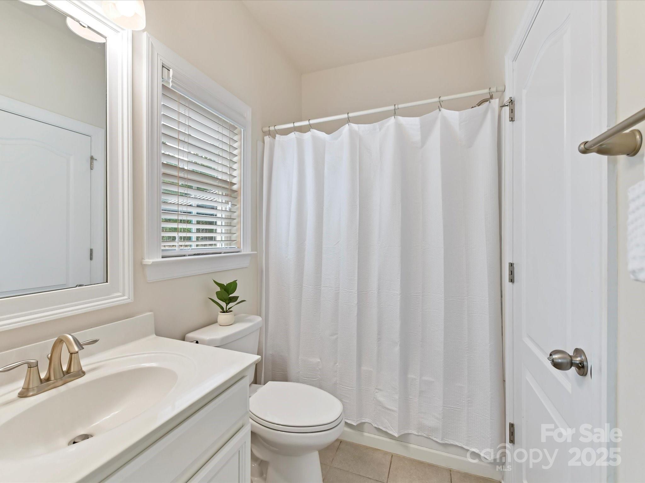 9895 Travertine Trail Davidson, NC 28036 - Photo 21 of 48 a bathroom with a sink a toilet and a mirror