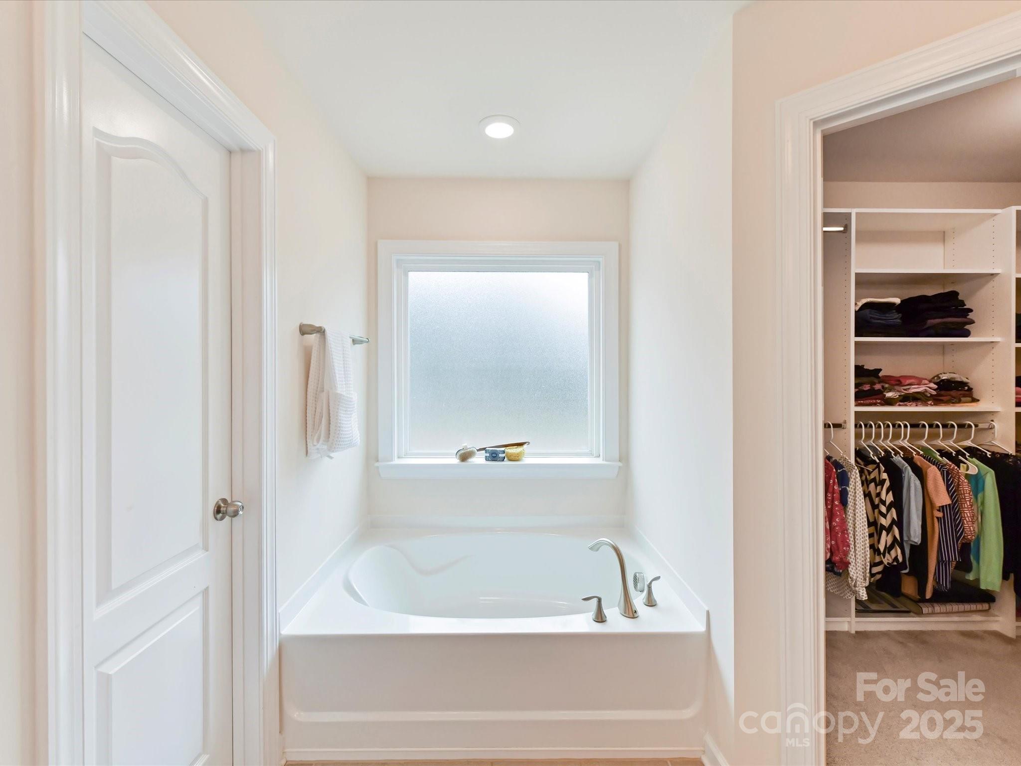 9895 Travertine Trail Davidson, NC 28036 - Photo 29 of 48 a bathroom with a bathtub and a shower