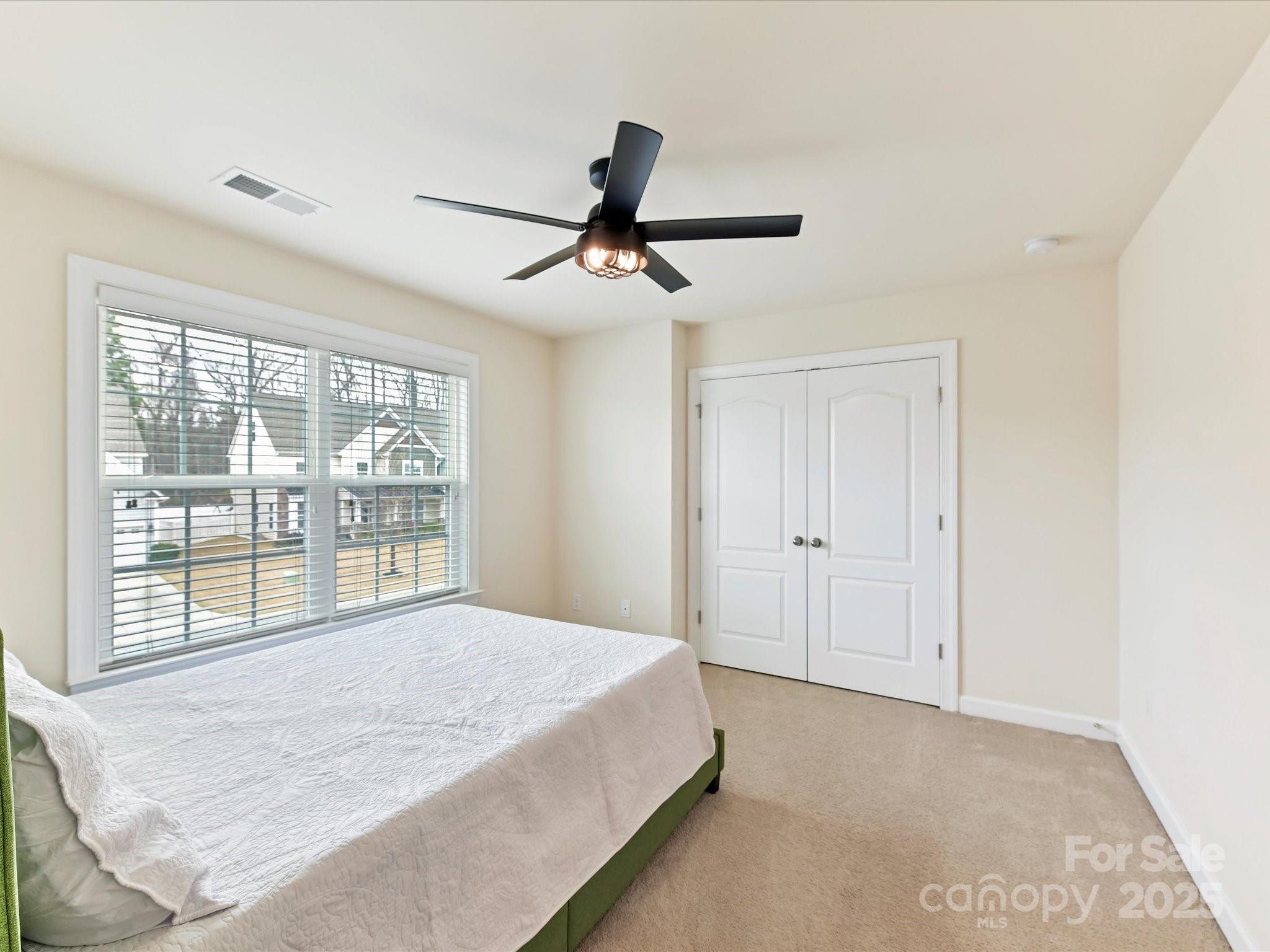 9895 Travertine Trail Davidson, NC 28036 - Photo 35 of 48 a bedroom with a large bed and a large window