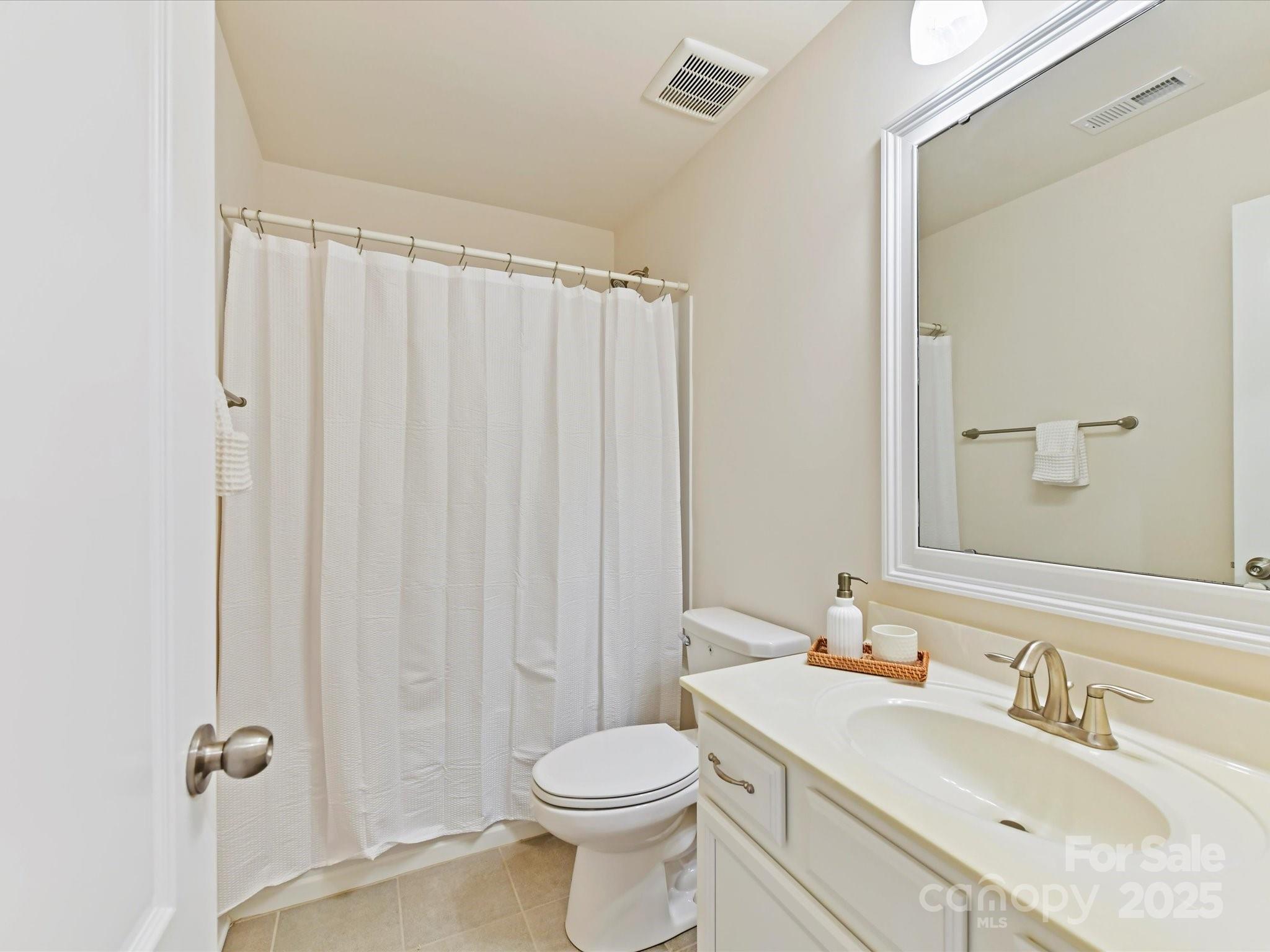 9895 Travertine Trail Davidson, NC 28036 - Photo 36 of 48 a bathroom with a granite countertop toilet sink and a mirror