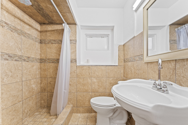 5322 West Addison Street Chicago, IL 60641 - Photo 16 of 21 a bathroom with a sink a toilet and shower