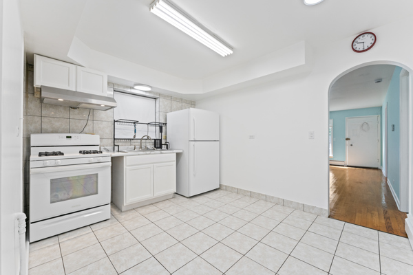 5322 West Addison Street Chicago, IL 60641 - Photo 8 of 21 a kitchen with white cabinets and white appliances