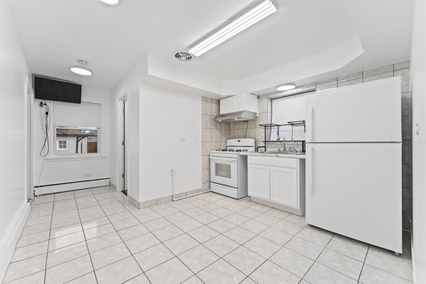 5322 West Addison Street Chicago, IL 60641 - Photo 9 of 21 a kitchen with white cabinets and white appliances
