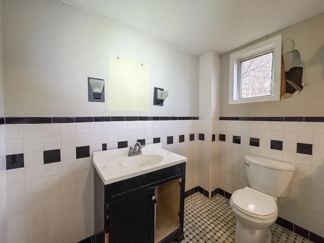 a bathroom with a sink a toilet and a mirror