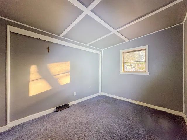 an empty room with a window and wooden floor
