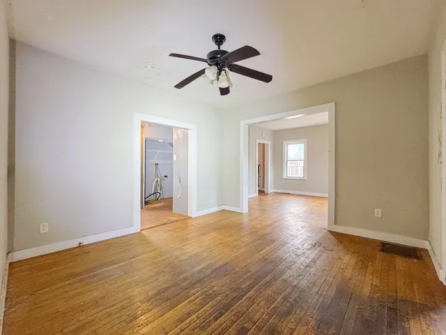 a view of empty room with wooden floor