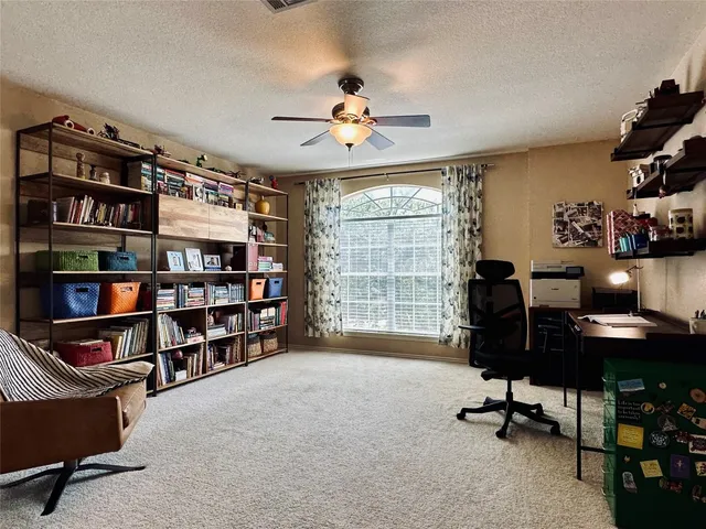 a view of a workspace with furniture and a bookshelf