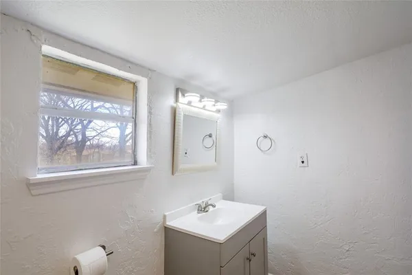 an empty room with a window and a fan