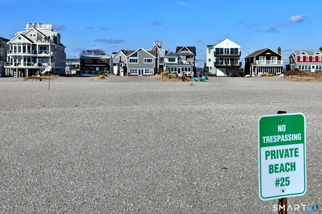 a view of multiple houses with yard and parking