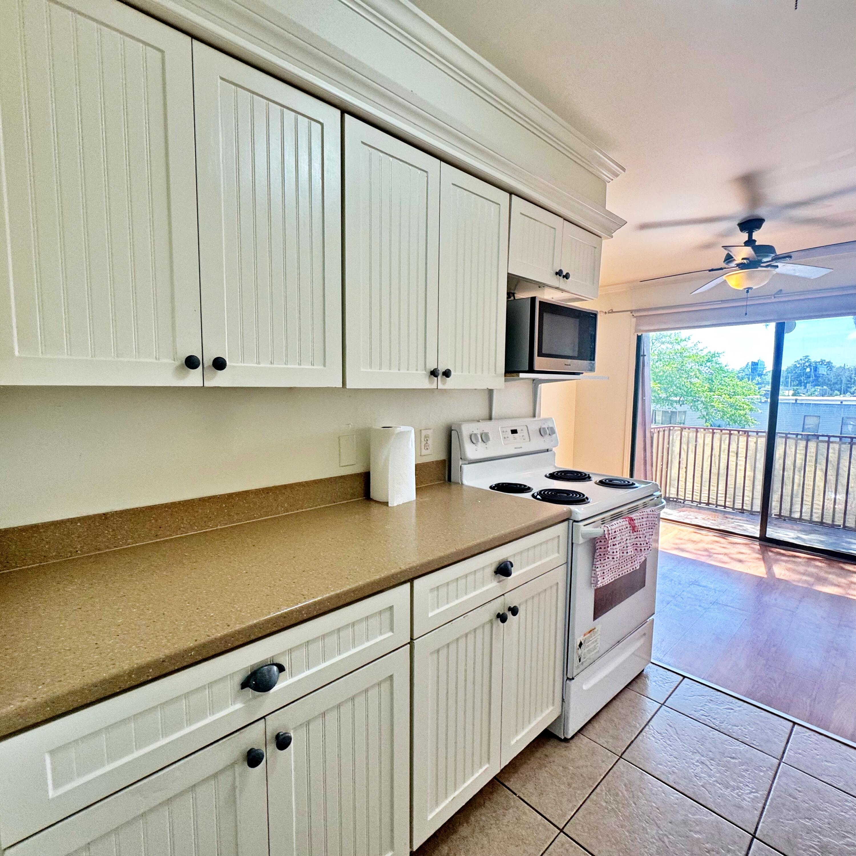 210 Pelham Road, Unit 215B Fort Walton Beach, FL 32547 - Photo 6 of 23 a kitchen with stainless steel appliances granite countertop a stove a sink and white cabinets