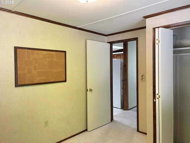 a view of an empty room with cabinet and a window