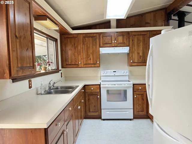 a kitchen with white cabinets and white appliances