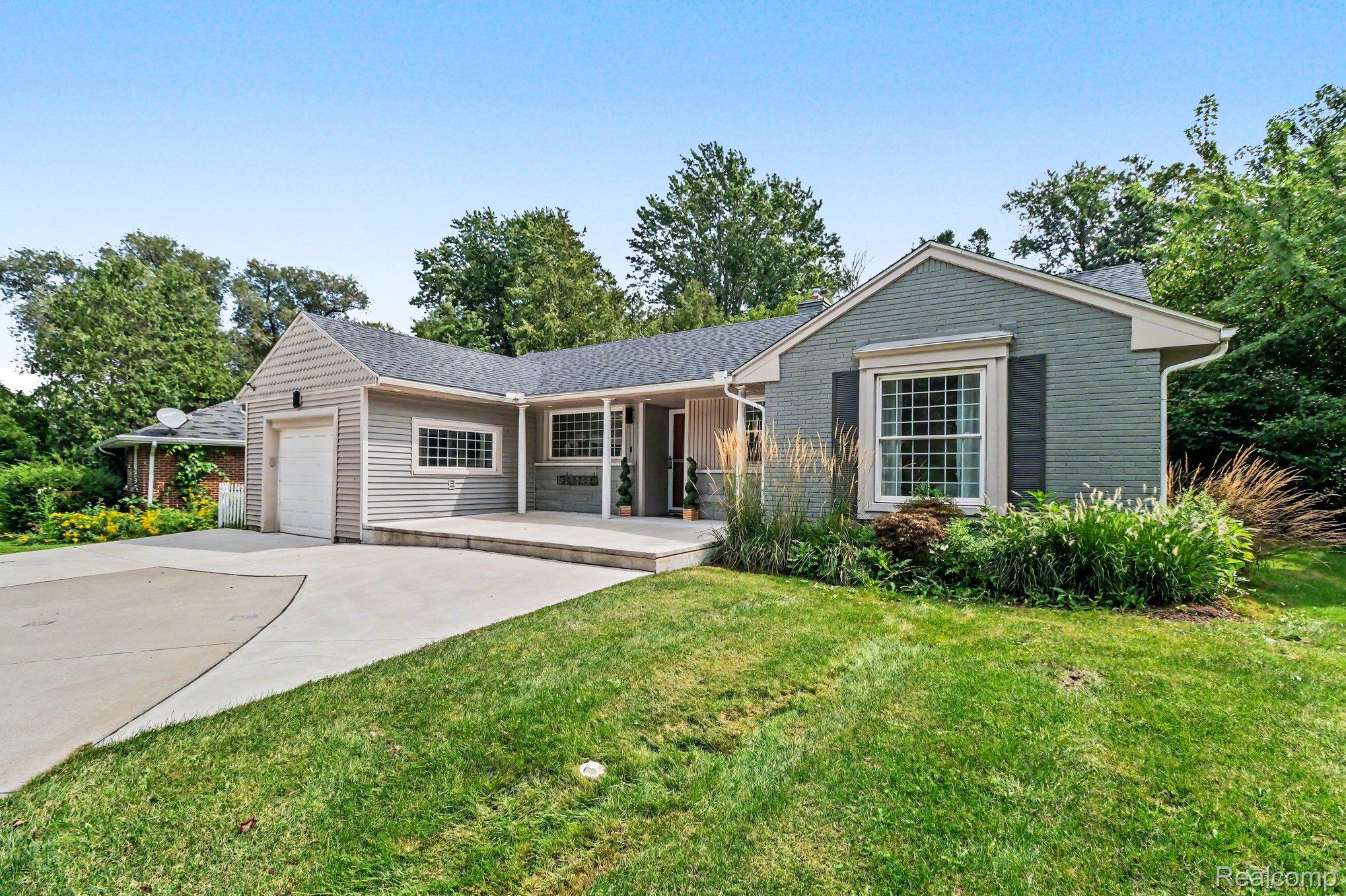 Ranch-style exterior with gray siding and brick facade