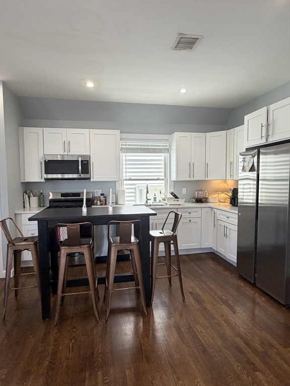 562 East 7th Street, Unit 2 Boston, MA 02127 - Photo 6 of 18 a kitchen with stainless steel appliances a table chairs sink refrigerator and cabinets