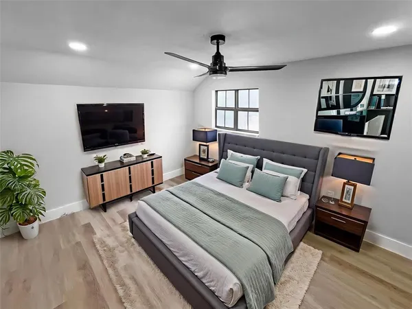 a bedroom with bed tv and window