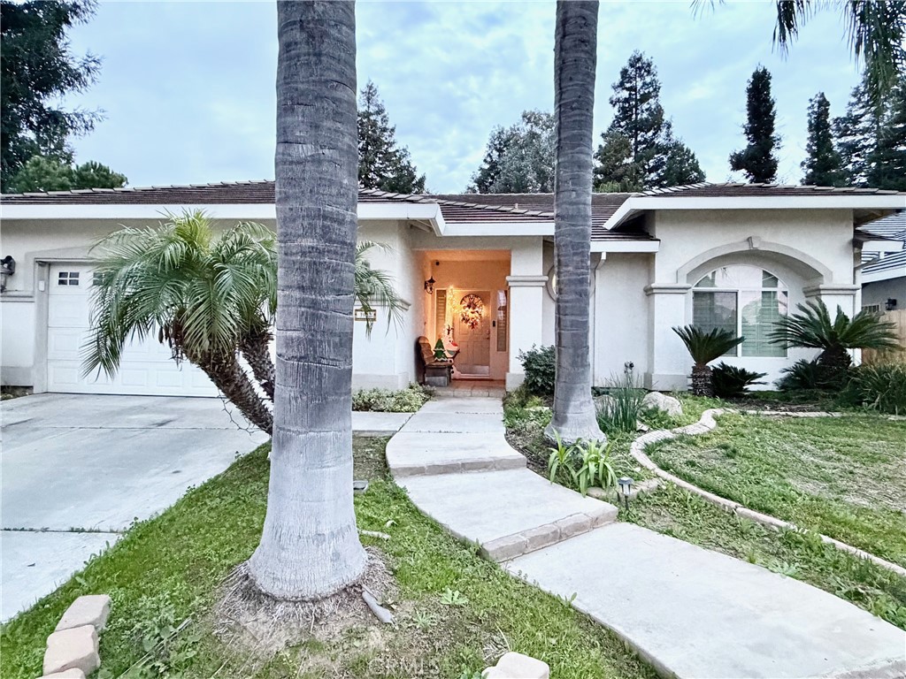 front view of house with a yard and potted plants