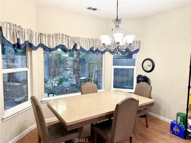 a view of a dining room with furniture a chandelier and wooden floor