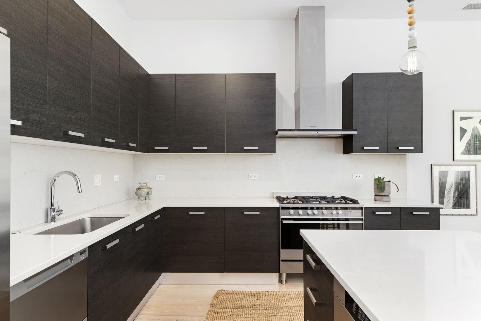 128 South Aberdeen Street, Unit 2N Chicago, IL 60607 - Photo 12 of 31 a kitchen with stainless steel appliances a sink a stove and a microwave with wooden floor