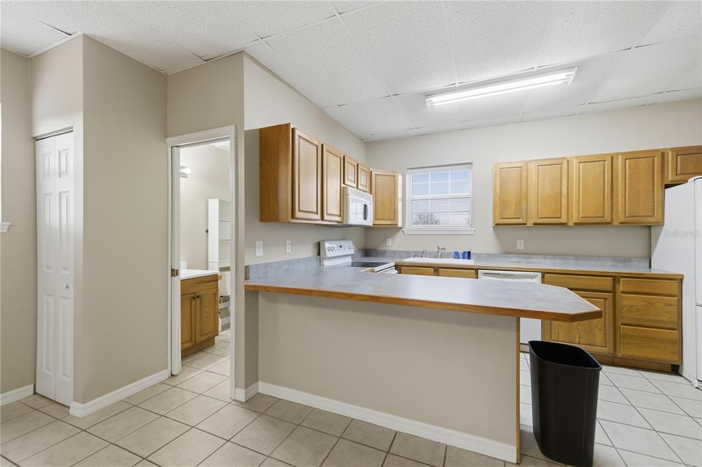9900 Southeast Sunset Harbor Road Summerfield, FL 34491 - Photo 15 of 44 a kitchen with stainless steel appliances a sink stove and cabinets