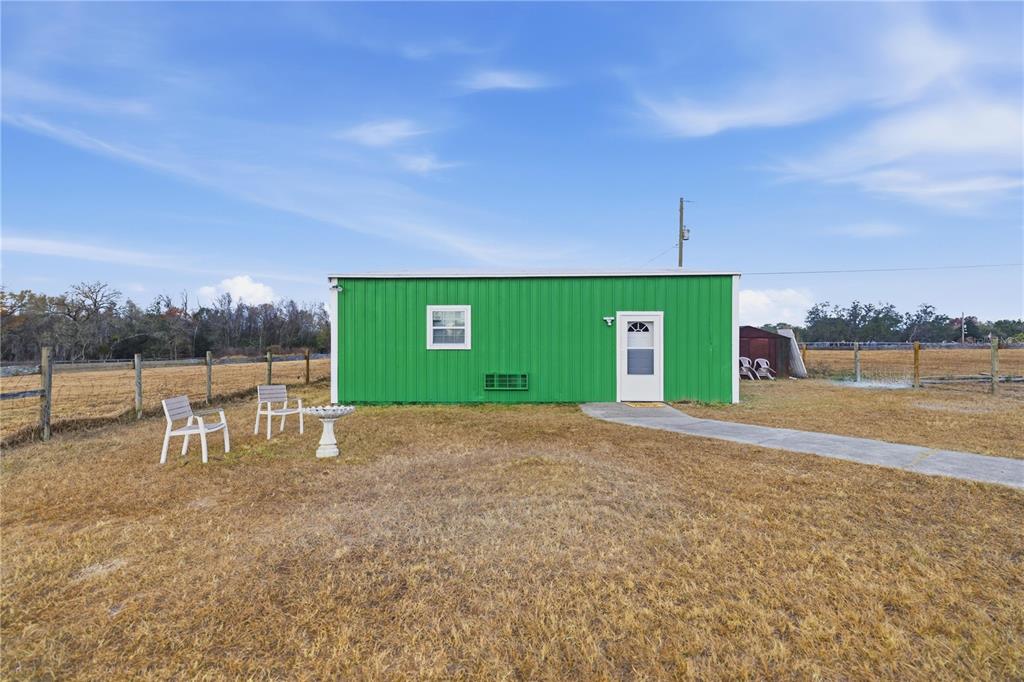 9900 Southeast Sunset Harbor Road Summerfield, FL 34491 - Photo 7 of 44 a view of a street with a building and a big yard