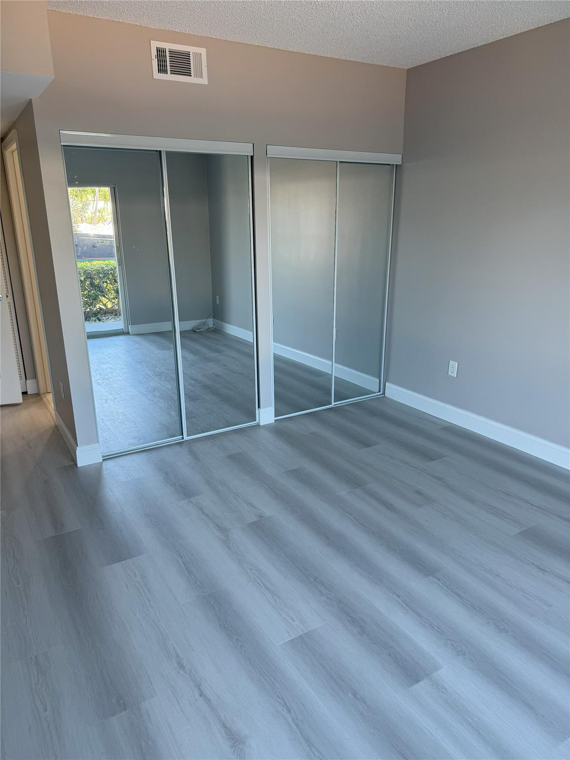 2731 Northeast 28th Court, Unit 3 Lighthouse Point, FL 33064 - Photo 31 of 33 an empty room with wooden floor closet and windows