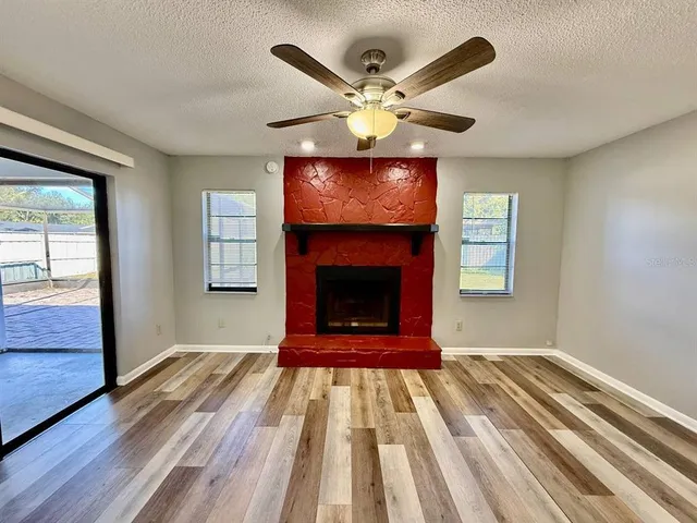 a view of an empty room with a fireplace and a window