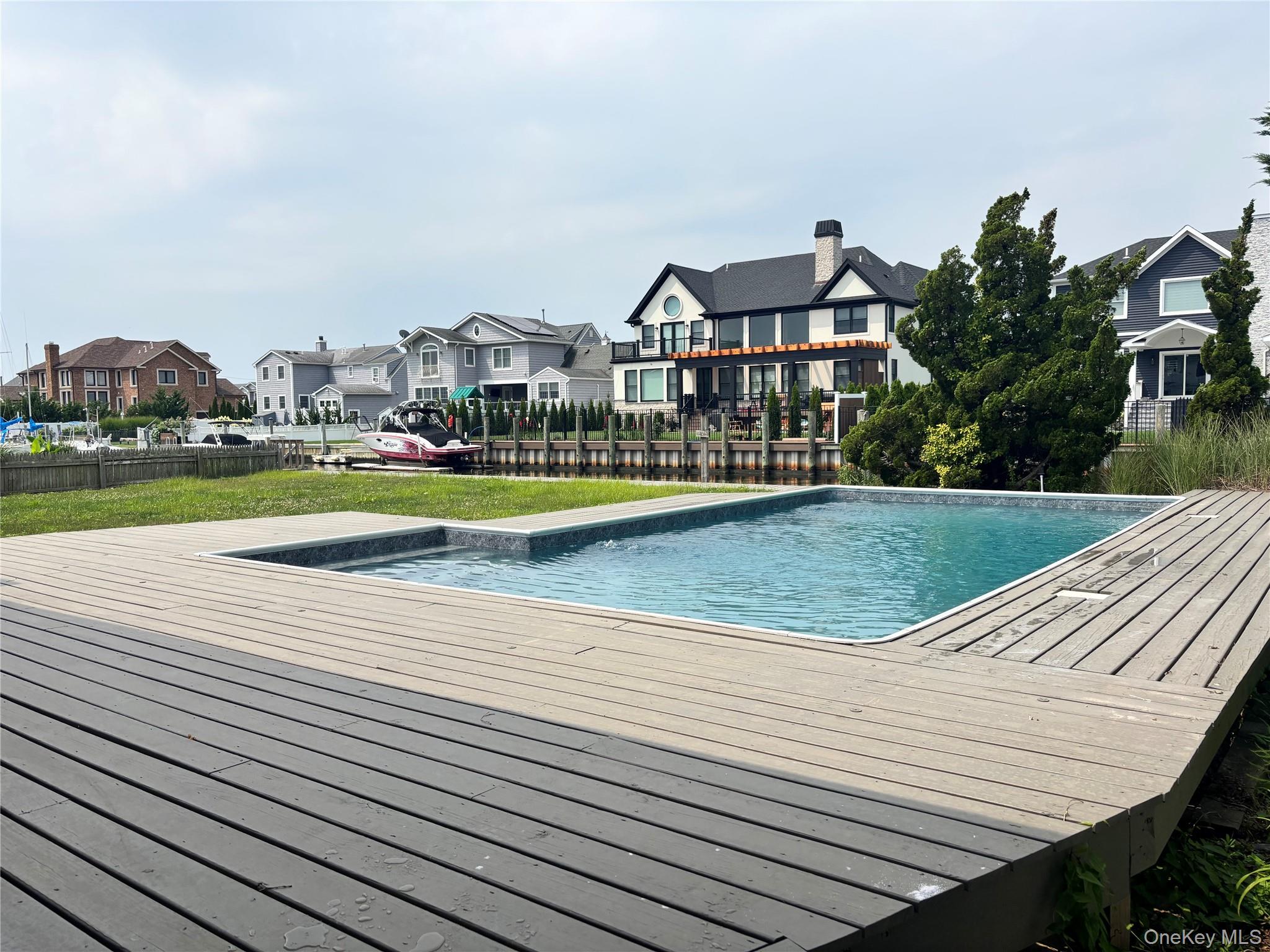 188 Sequams Lane Centre West Islip, NY 11795 - Photo 23 of 27 a view of a swimming pool with a lawn chairs and plants