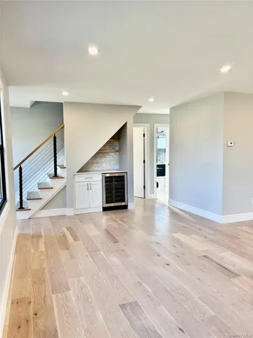 a view of a livingroom with wooden floor and staircase