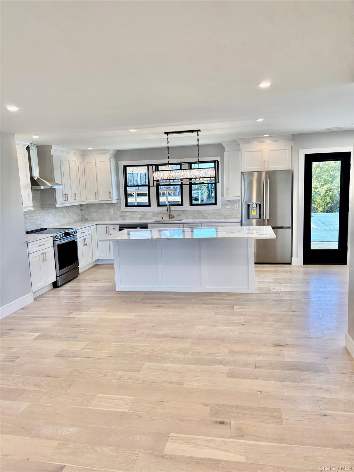 188 Sequams Lane Centre West Islip, NY 11795 - Photo 5 of 27 a living room with stainless steel appliances kitchen island a cabinets wooden floor and a fireplace
