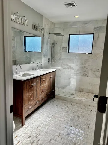 a bathroom with a double vanity sink mirror and