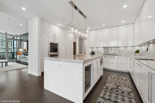 a large white kitchen with lots of counter space wooden floor and appliances