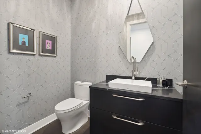 a bathroom with a granite countertop toilet sink and mirror