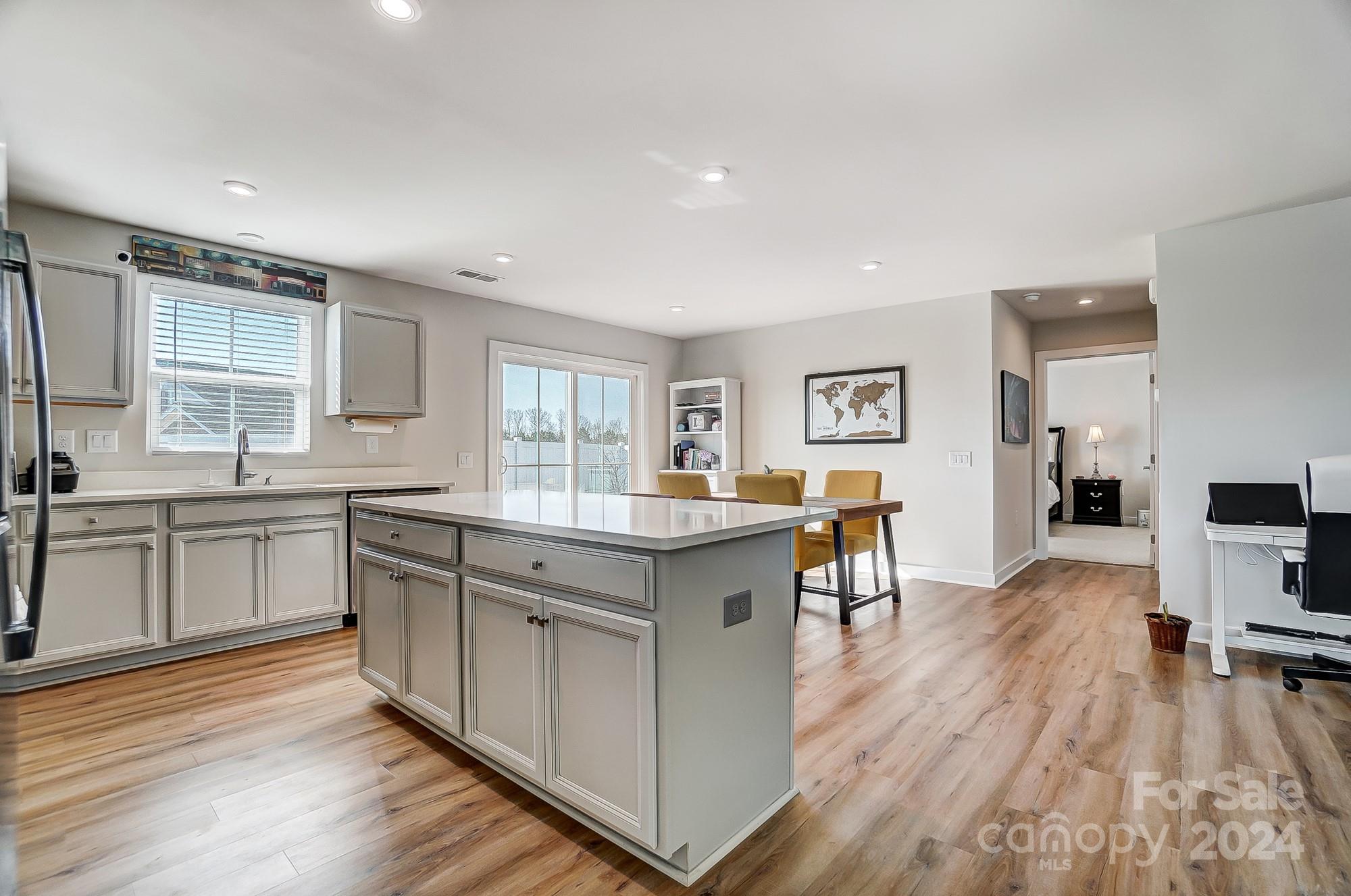 4136 Mackinnon Drive Charlotte, NC 28214 - Photo 12 of 48 a kitchen with stainless steel appliances granite countertop a stove top oven a sink a dining table and chairs with wooden floor