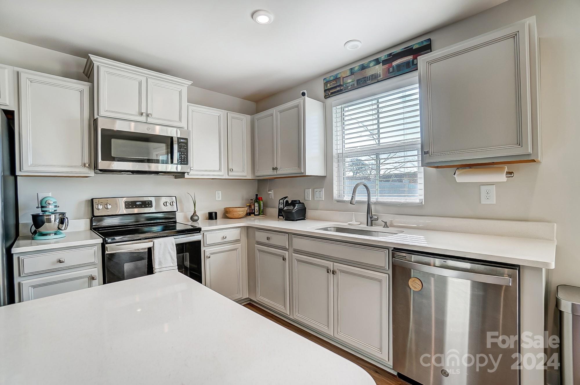 4136 Mackinnon Drive Charlotte, NC 28214 - Photo 14 of 48 a kitchen with white cabinets appliances a sink and a window