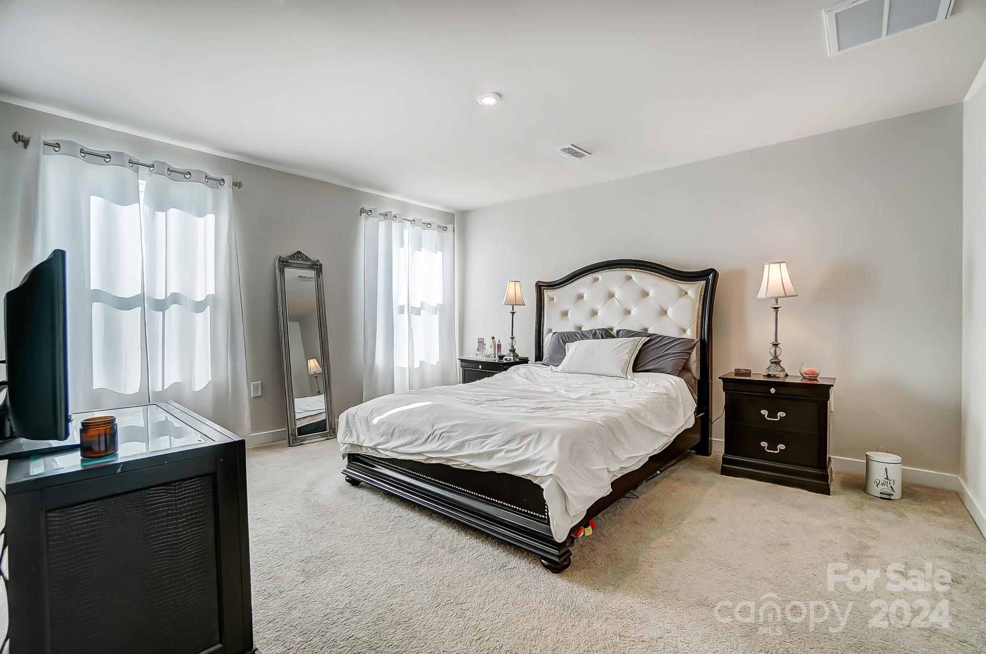 4136 Mackinnon Drive Charlotte, NC 28214 - Photo 19 of 48 a bedroom with a bed and a flat tv screen on dresser