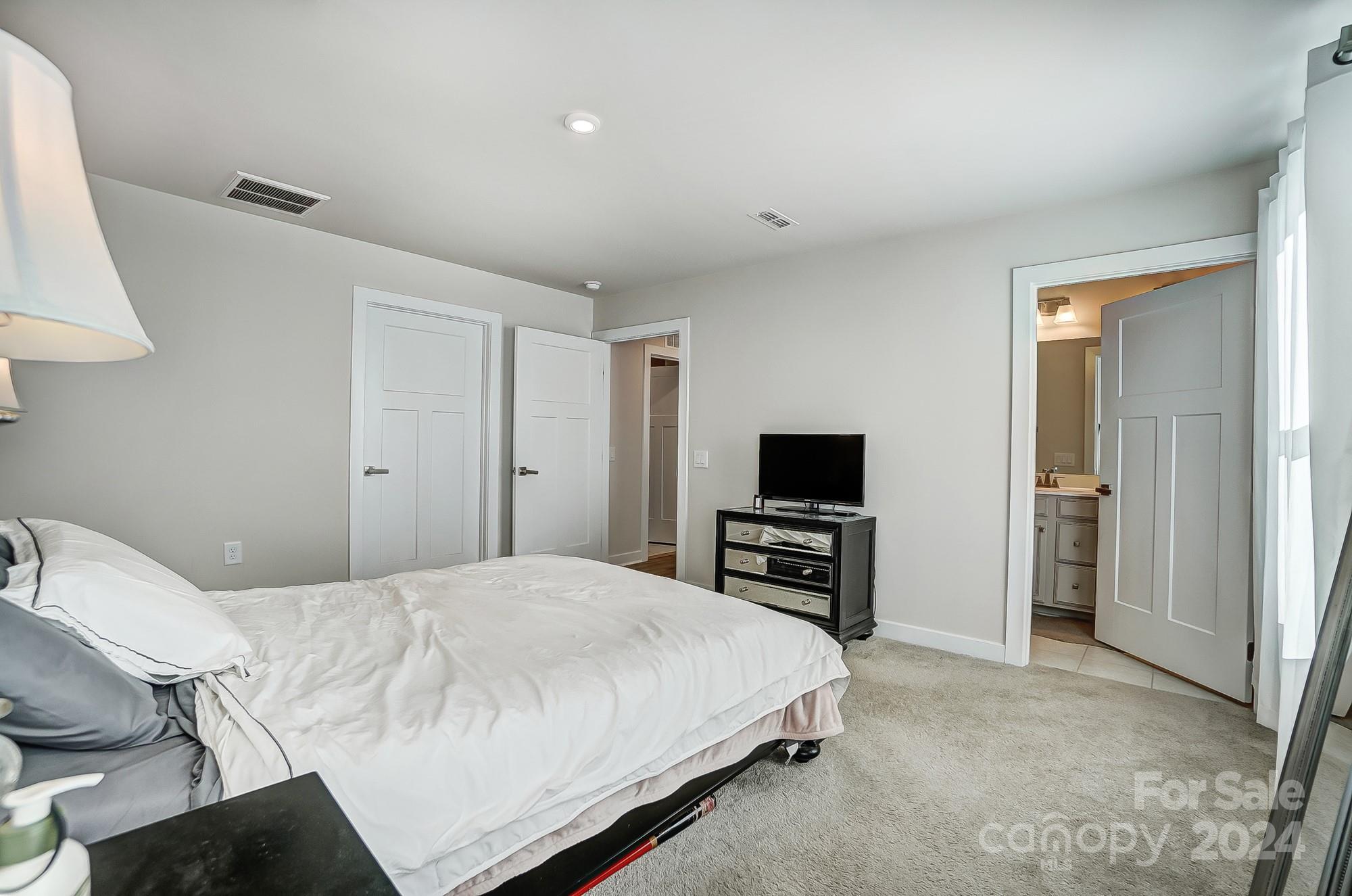 4136 Mackinnon Drive Charlotte, NC 28214 - Photo 21 of 48 a bedroom with a bed and a flat screen tv