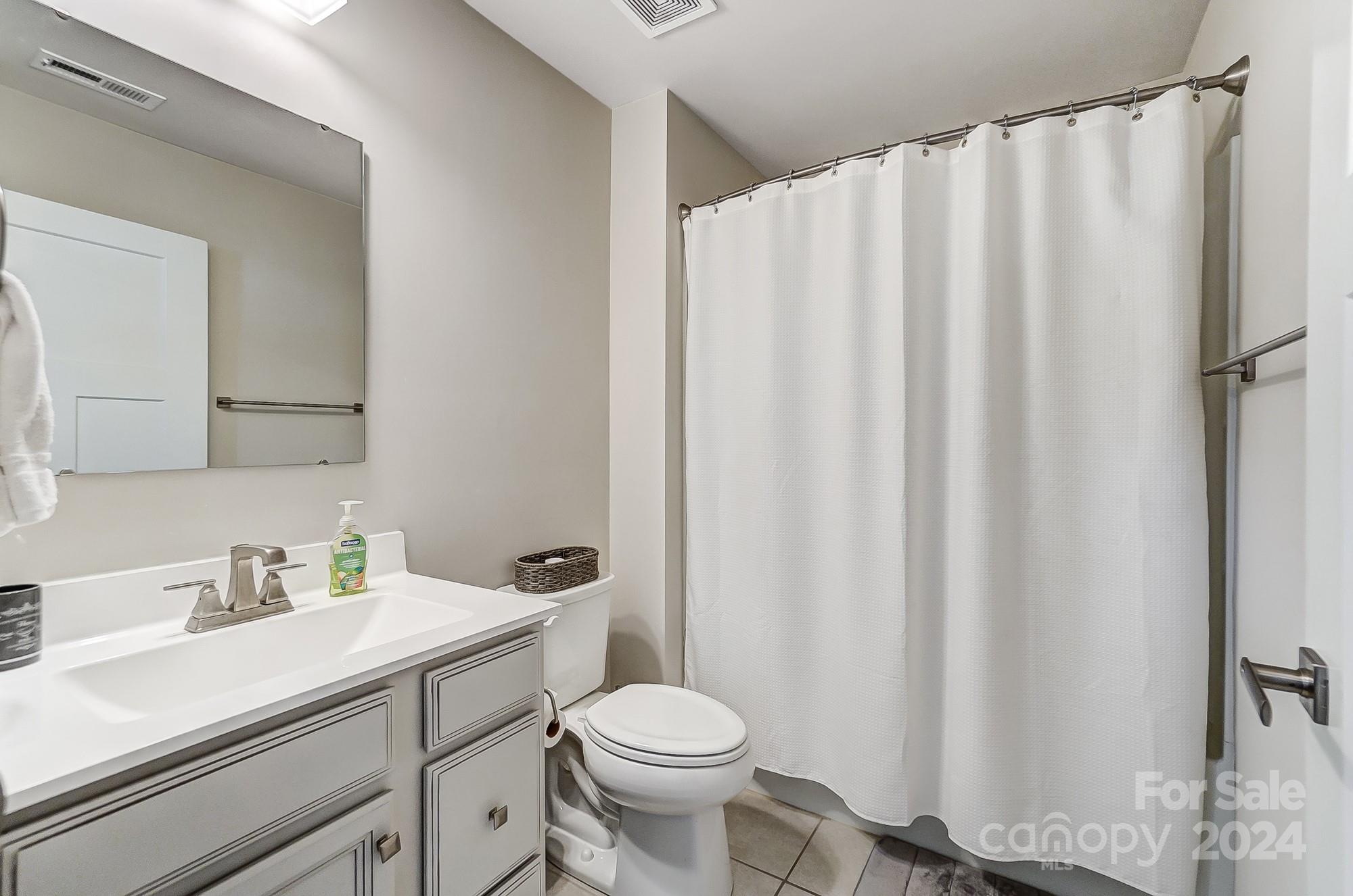 4136 Mackinnon Drive Charlotte, NC 28214 - Photo 31 of 48 a bathroom with a sink a toilet and shower curtain
