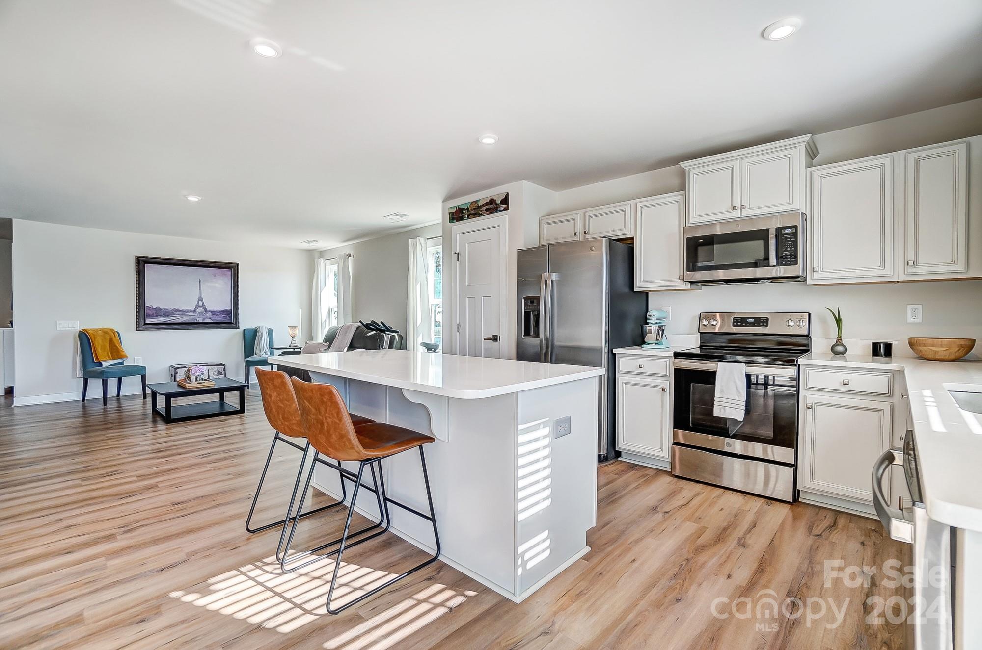 4136 Mackinnon Drive Charlotte, NC 28214 - Photo 10 of 48 a kitchen with stainless steel appliances a stove a sink a microwave a dining table and chairs