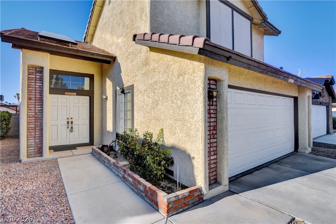 6440 Hartwood Road Las Vegas, NV 89108 - Photo 3 of 59 A classic stucco and brick façade welcomes you with a traditional double-door entry and an attached garage.