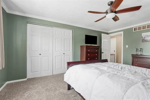 a bedroom with a bed and a flat tv screen on dresser