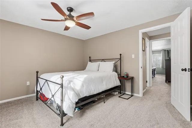 a bed room with a bed and a ceiling fan