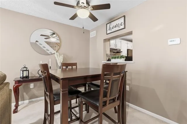 a view of a dining room with furniture and a chandelier fan