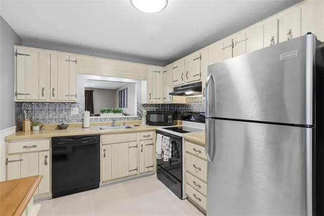 a kitchen with stainless steel appliances a refrigerator sink and cabinets