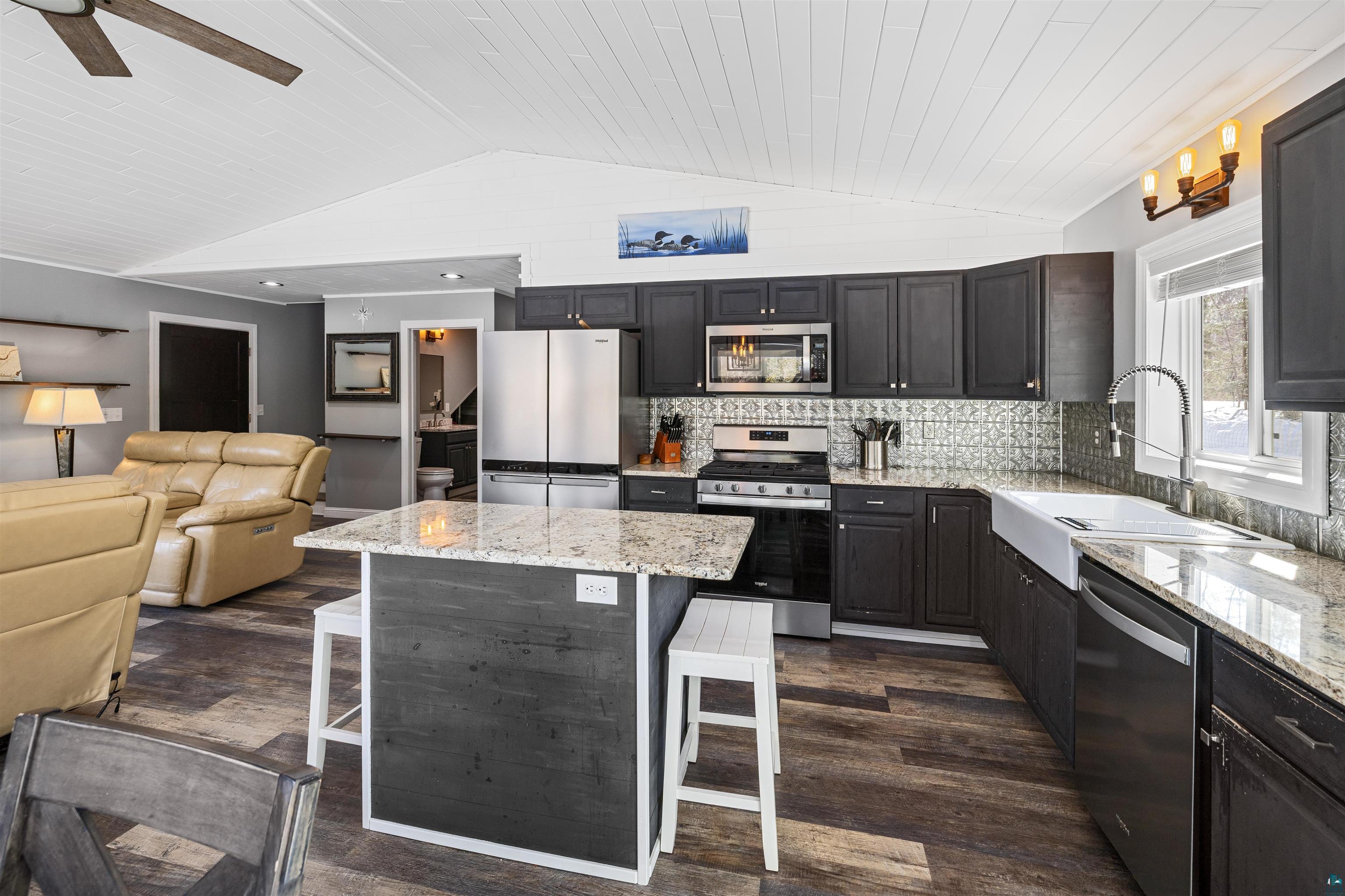 13462 Villa Road Ely, MN 55731 - Photo 63 of 68 Kitchen featuring stainless steel appliances, granite countertops, open floor plan, a kitchen island, and a breakfast bar