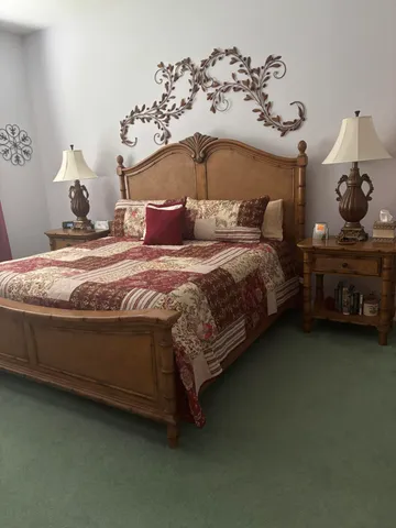 a bedroom with bed and dresser with mirror