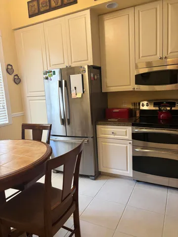 a kitchen with a stove a sink and white cabinets